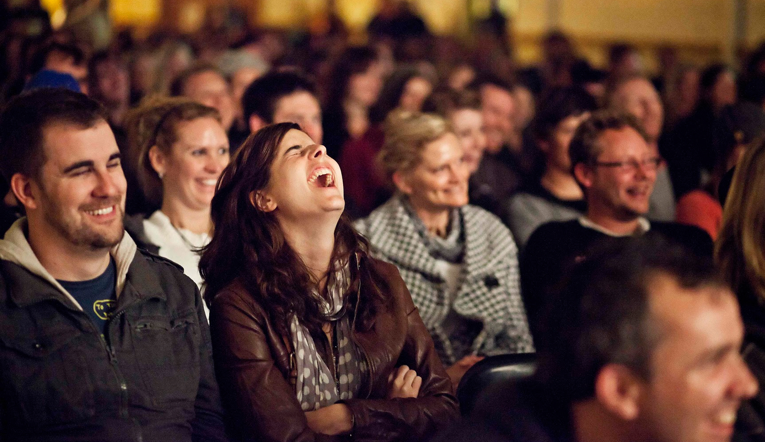 Восторг публики. Зрители смеются. Зрители в зале театра. Зрители в зале смеются. Толпа смеется.